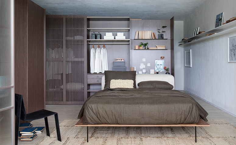 guarda-roupa integrado ao quarto com prateleiras arejadas e portas que permitem ventilação para evitar o mofo.