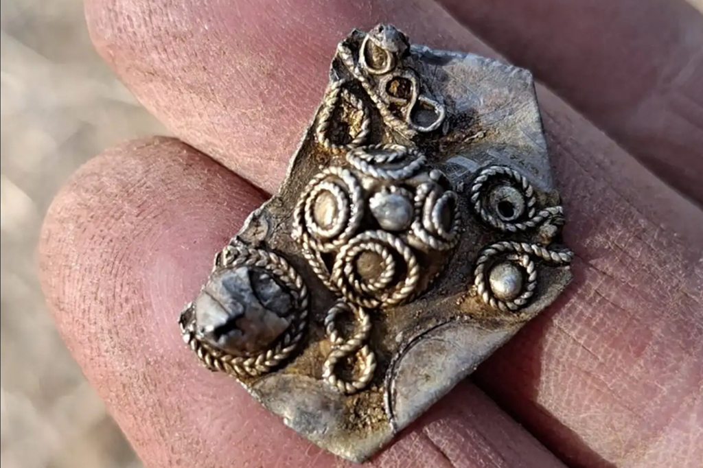 Fotografia de fragmento de um broche de prata, também conhecido como