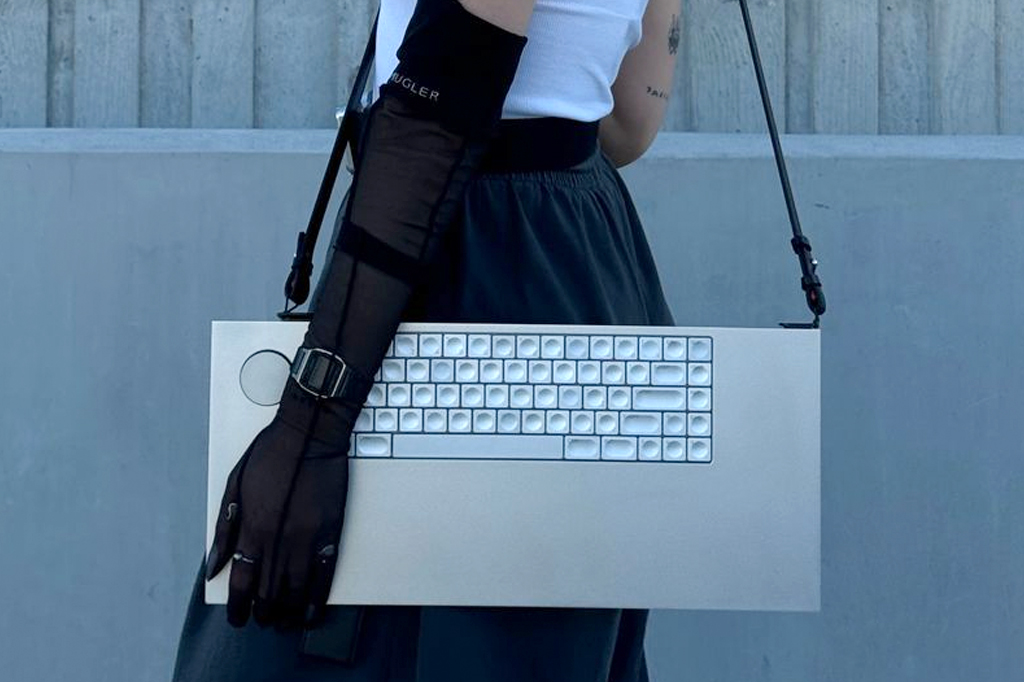 Imagem de uma mulher carregando um teclado com alças de bolsa.