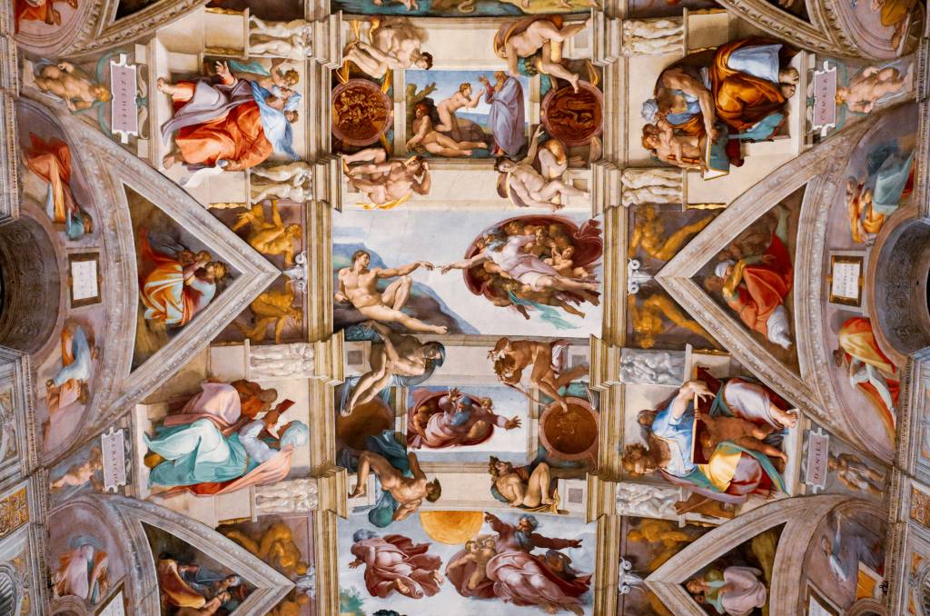 Teto da Capela Sistina, com afrescos de Michelangelo. No centro, A Criação de Adão, com Deus e Adão estendendo os dedos. Ao redor, cenas bíblicas e figuras de profetas e sibilas em painéis retangulares e triangulares, com molduras arquitetônicas pintadas, em tons terrosos, azuis e vermelhos